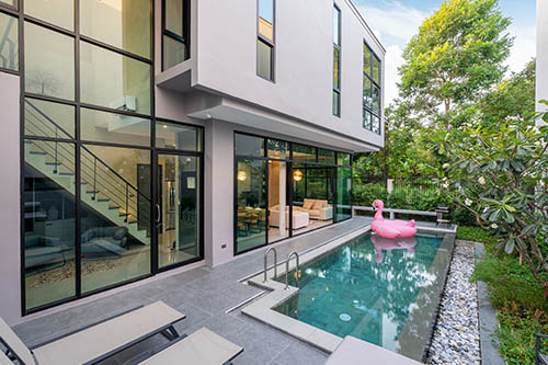 A pool in the middle of a house with a pink flamingo.